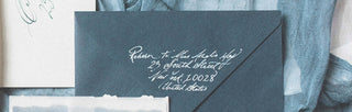 navy envelope with white calligraphy address