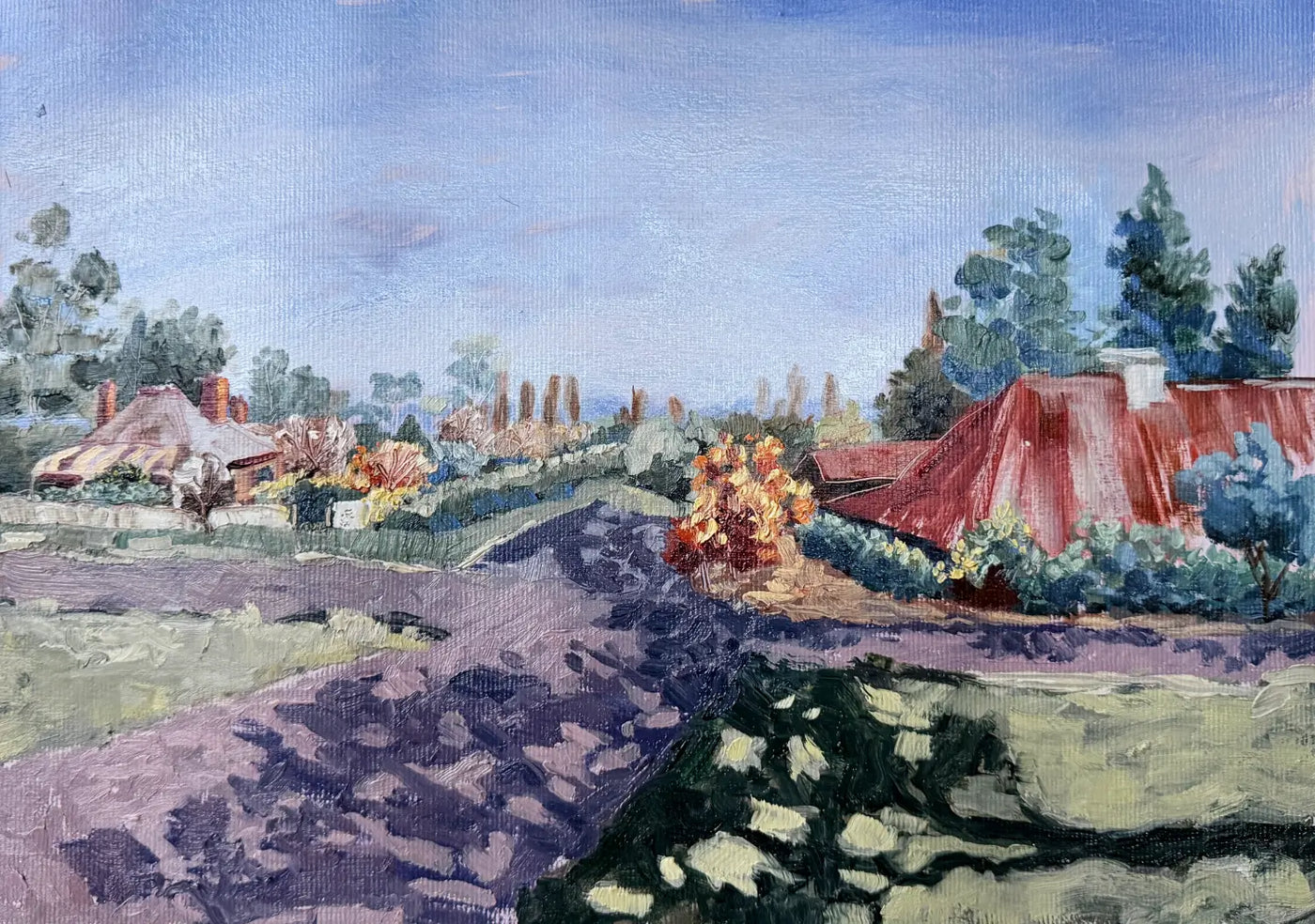 A landscape oil painting depicting a rural village in New South Wales, red-roofed houses, green trees, and a blue sky. Gundaroo view from the church towards the 'grazing' restaurant and wedding venue.