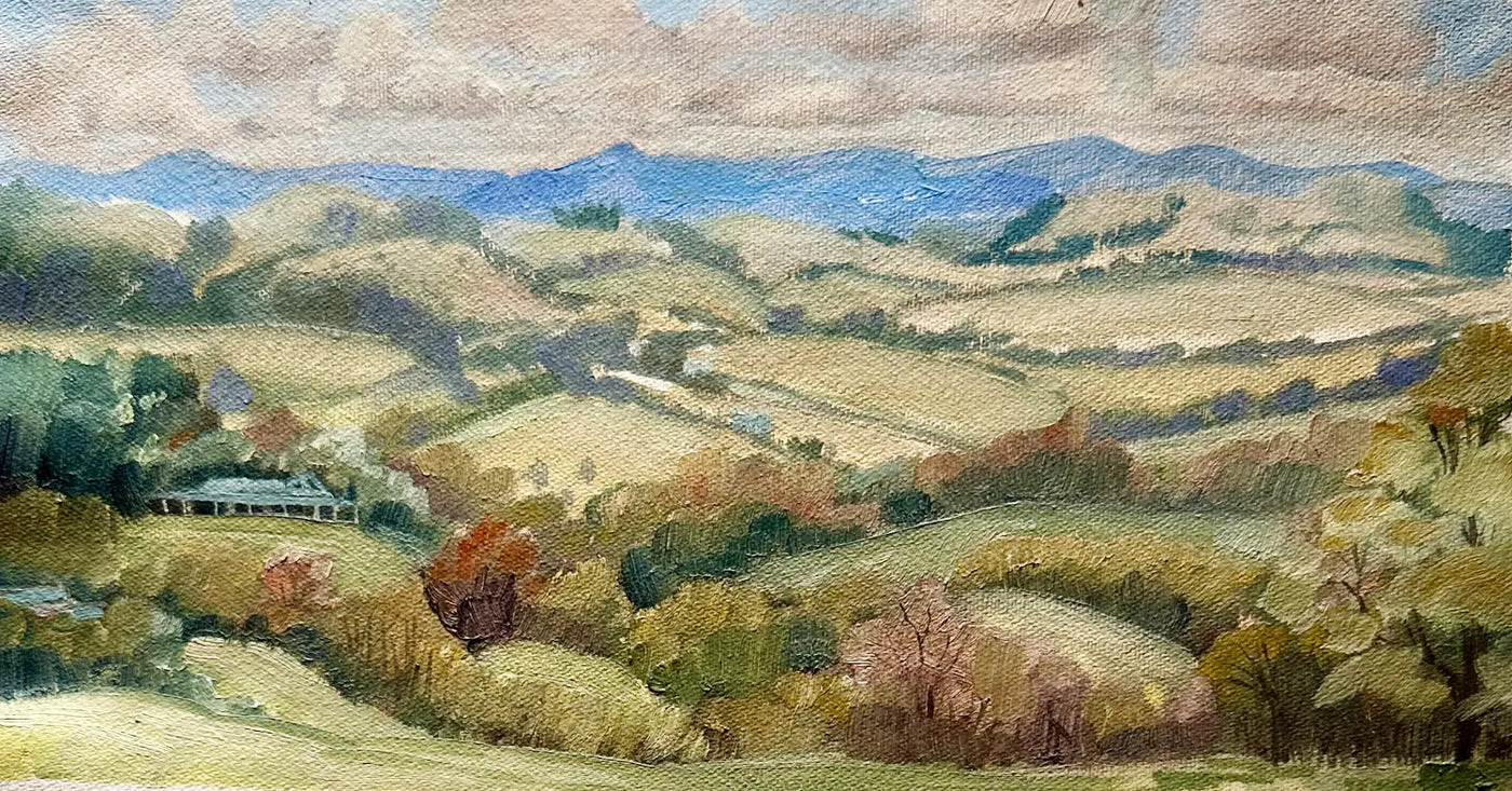 Australian oil landscape painting of rolling hills, fields, distant blue mountains, and a cloudy sky, with a small homestead visible on the left side. Painted en plein air.