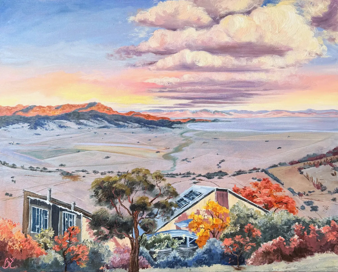 A custom house portrait painted in oils. A colourful landscape painting depicting a wide valley with distant mountains, Lake George in New South wales, the road through the flats, and an eco build house in the foreground surrounded by trees and autumn-colored shrubs under a dramatic cloudy sky.