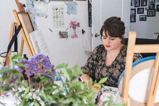 woman painting watercolours in her light filled vintage studio