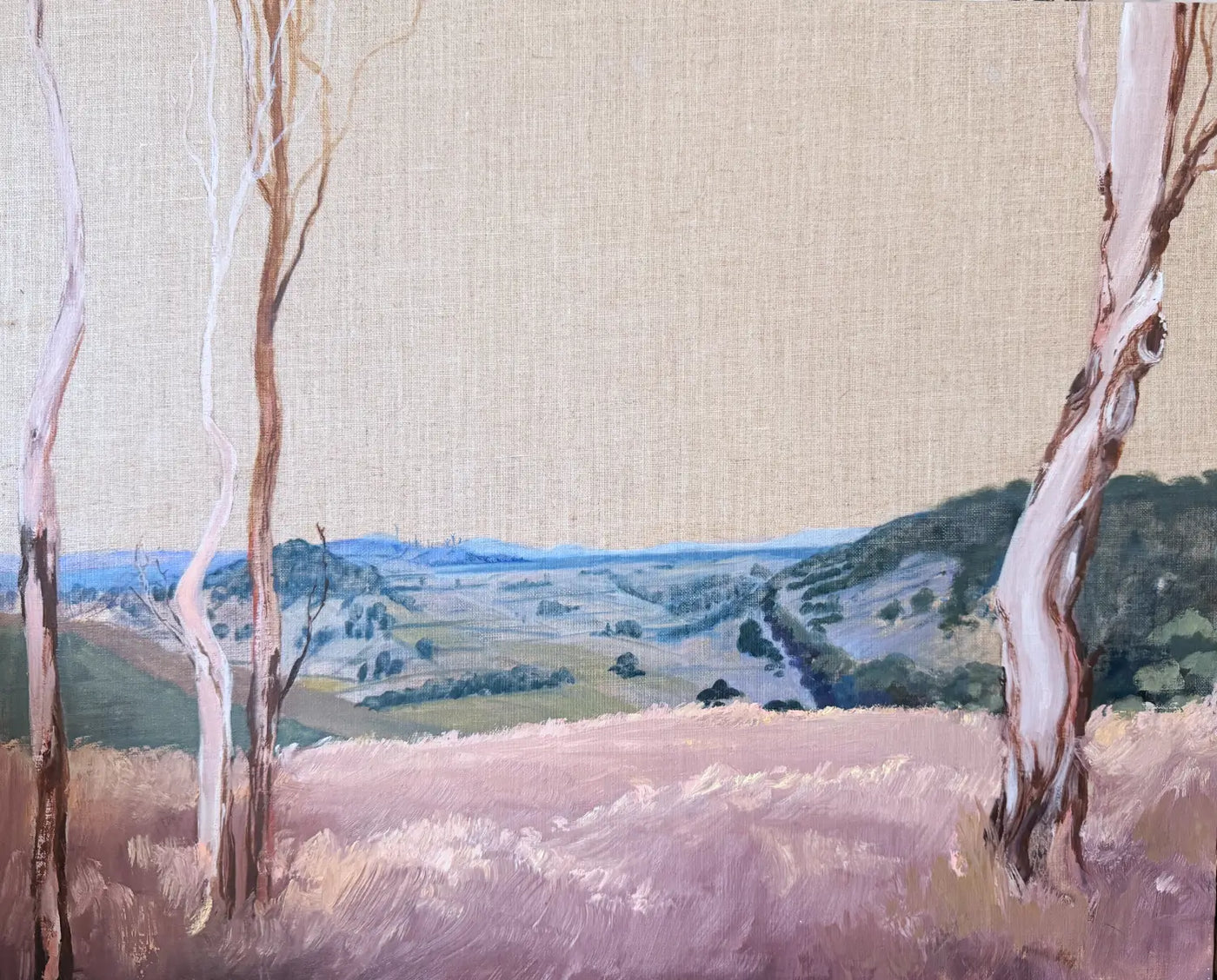 Painted en plein air in rural Australia. An impressionistic landscape painting featuring a soft beige sky, a lavender field in the foreground, and distant blue hills framed by tall, pale gum trees. Looking out over St George lake iin New South Wales.