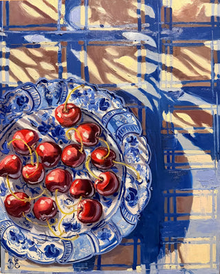 A still life painting of red cherries on a blue and white patterned Japanese plate, set against a blue and beige check tablecloth background with painterly shadows.